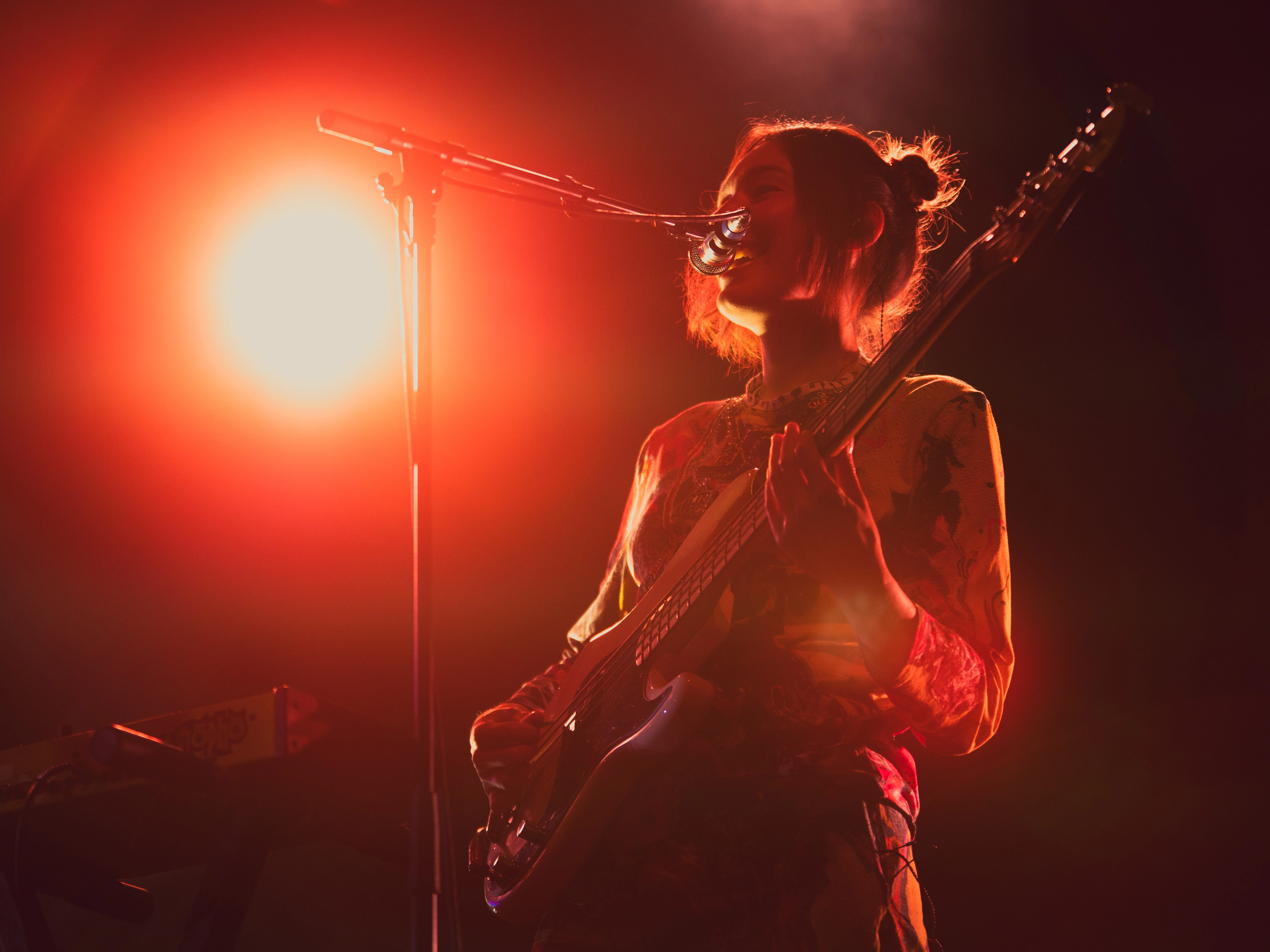 Chanteuse sur scène, micro à la main et projecteurs colorés.