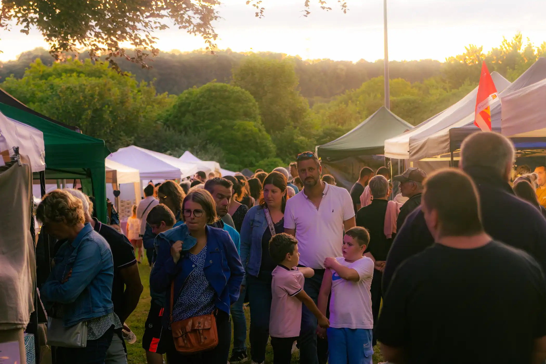 Foule du Grand Marché Nocturne des Barons, bras levés face à la scène.